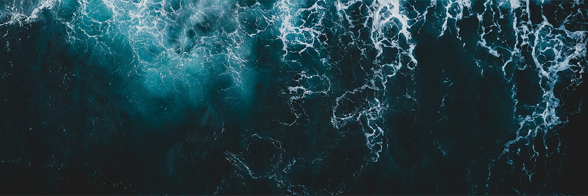 An image of the darkest part of the ocean with waves and foam. Photo by Ivan Bandura at Unsplash